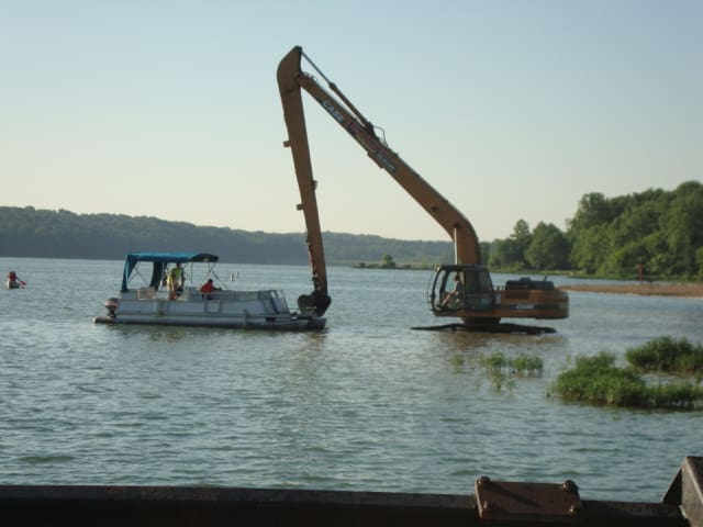 A boat is being pulled by a crane in the water.