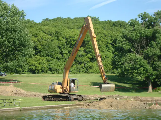 A large crane is in the middle of a field.