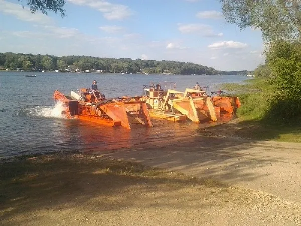 A boat with many orange parts is in the water.