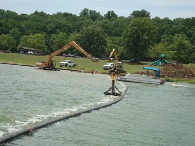 A large body of water with construction equipment in the background.