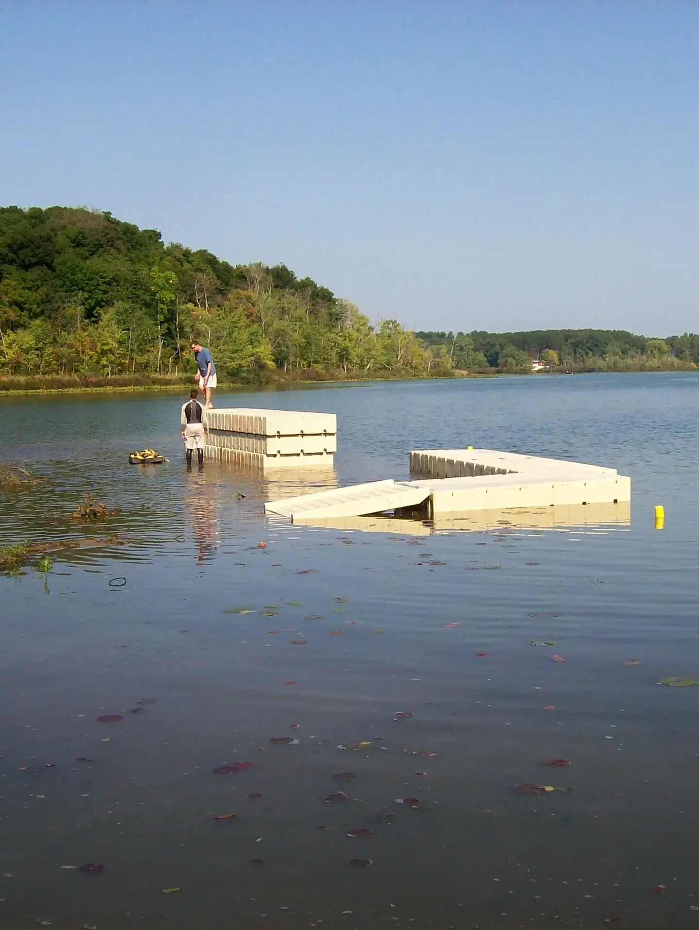 A dock with two piers in the middle of a lake.