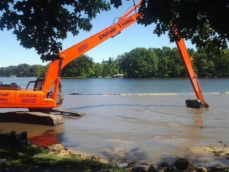 A large orange crane is in the water.