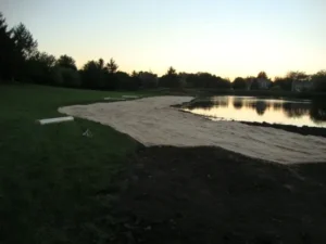 A sandy beach next to a body of water.