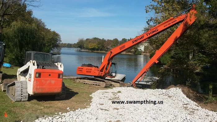 A large orange crane is in the foreground of a river.