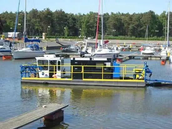 A boat is docked in the water near many other boats.