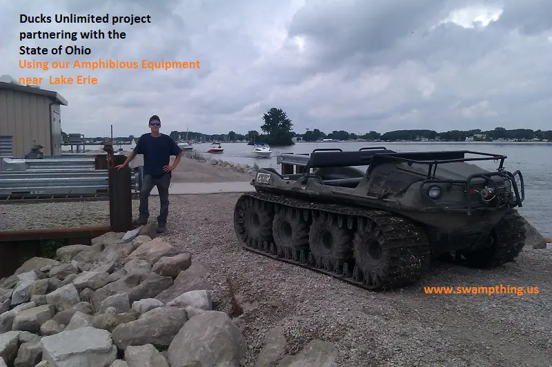 A man standing next to an army tank.