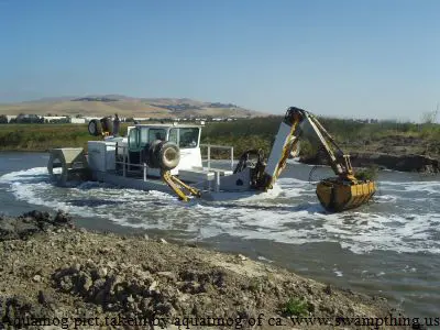 A large yellow and white truck in the water.